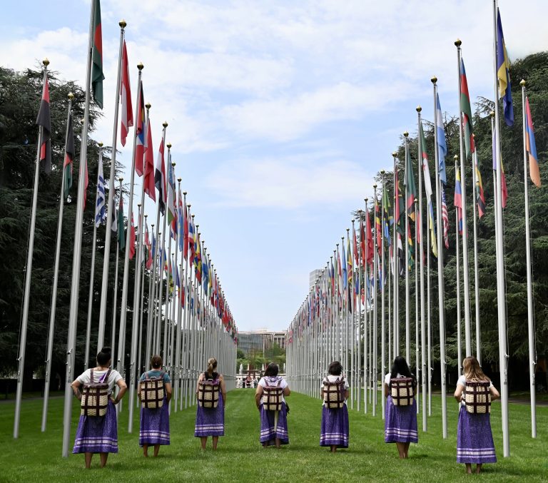 women standing before series of tall flags